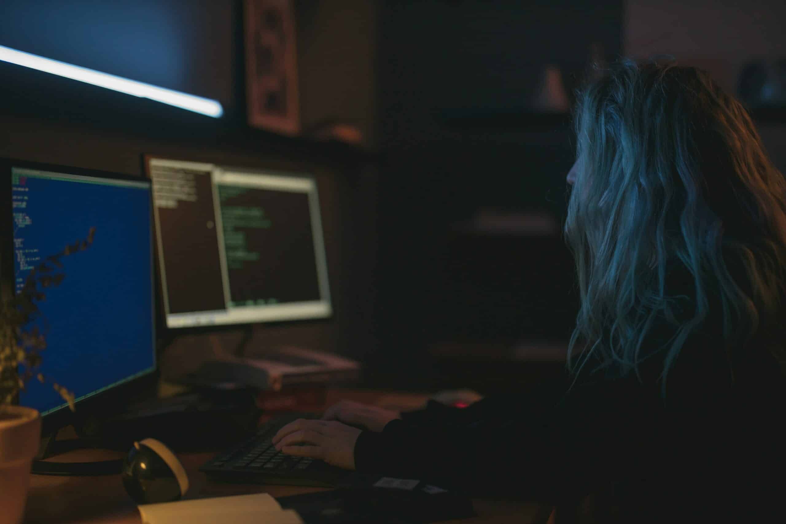 Person in dark room on computer, Cybersecurity, Ransomware Protection