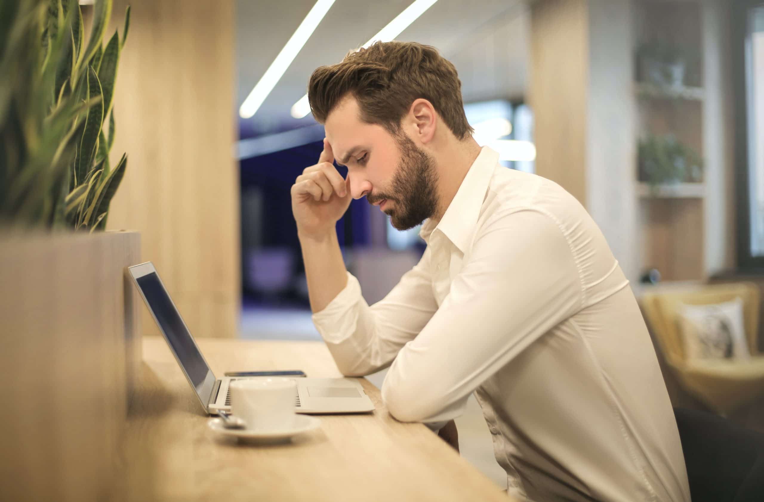 Man at table looking at laptop, Cyberscore, cybersecurity companies Chicago
