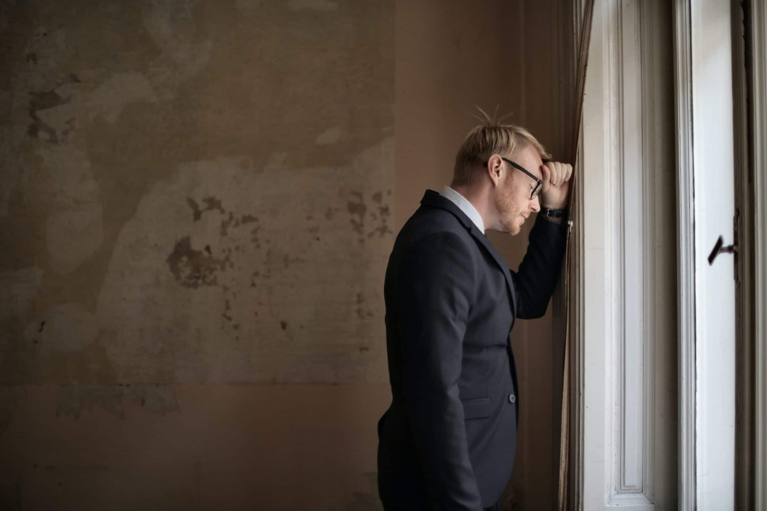 Man standing inside room looking out window, Cyberscore, cybersecurity companies Chicago