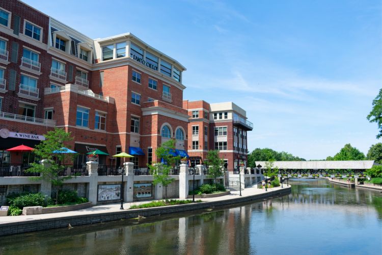A downtown area with brick buildings next to a river in Naperville, Illinois