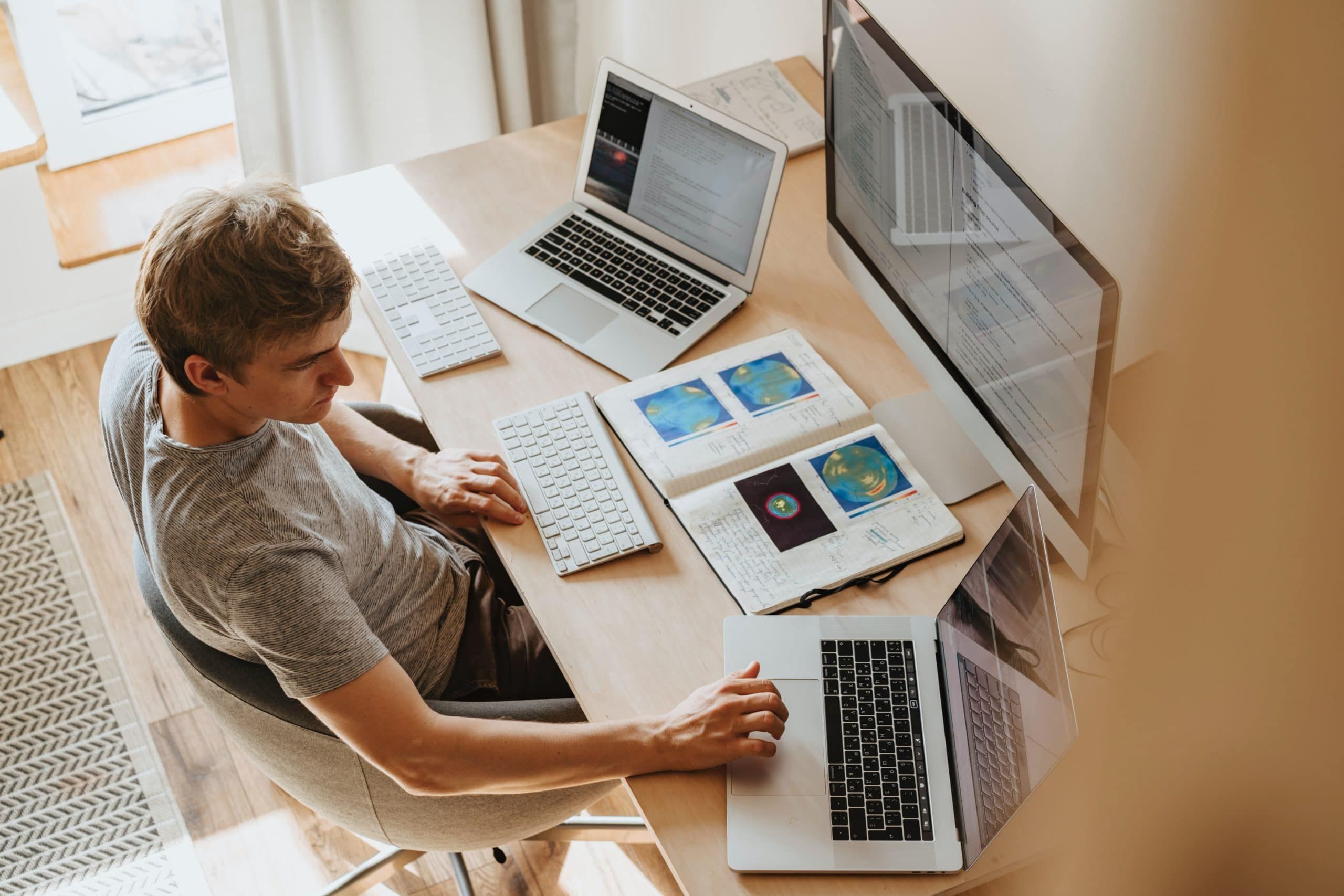 Man sitting at table with two laptops and monitor, Cyberscore, cybersecurity companies Chicago
